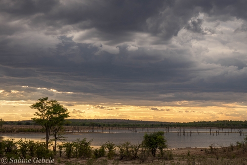 Ein Gewitter braut sich ueber Mandavu Dam im Hwange National Park zusammen